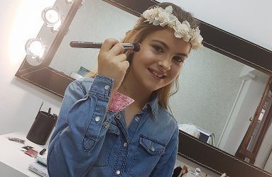 Niña de comunión con brocha de maquillaje