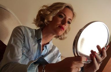 Otra invitada revisando su maquillaje con espejo