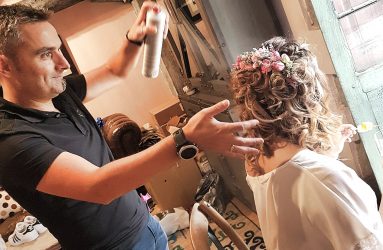 Peluquero aplicando laca para peinado de invitada