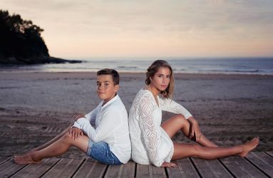 Jóvenes sentados con la playa de fondo